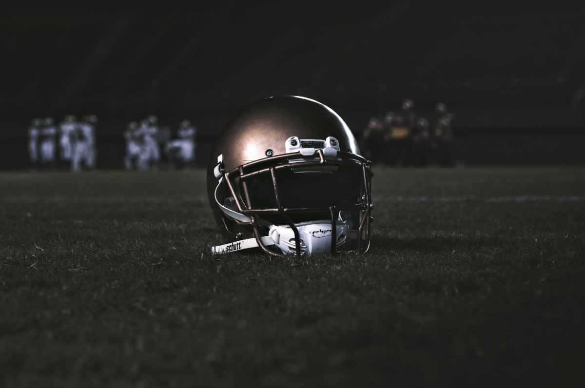 Football helmet in the middle of field, Friday Night Lights style. 